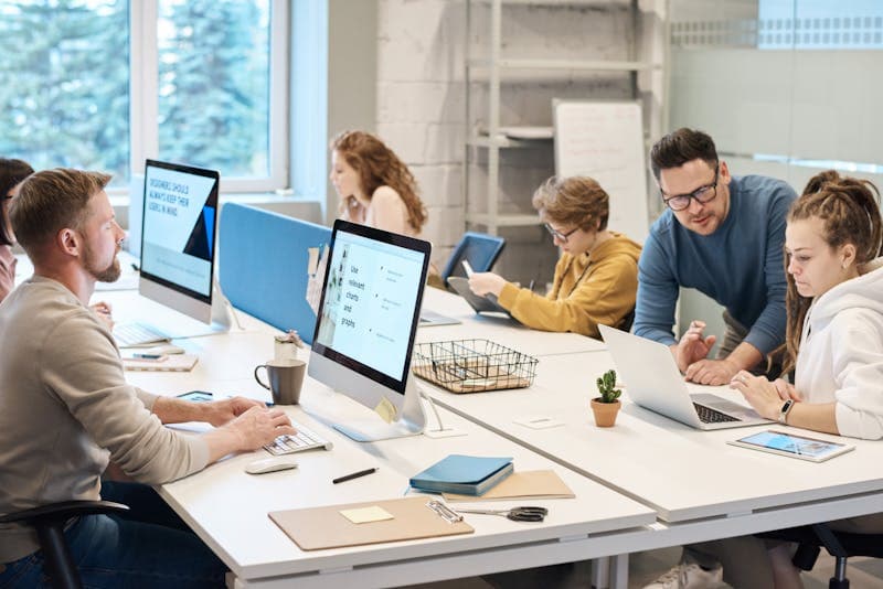 Equipe de freelances collaborant autour d'un ordinateur portable dans un bureau lumineux